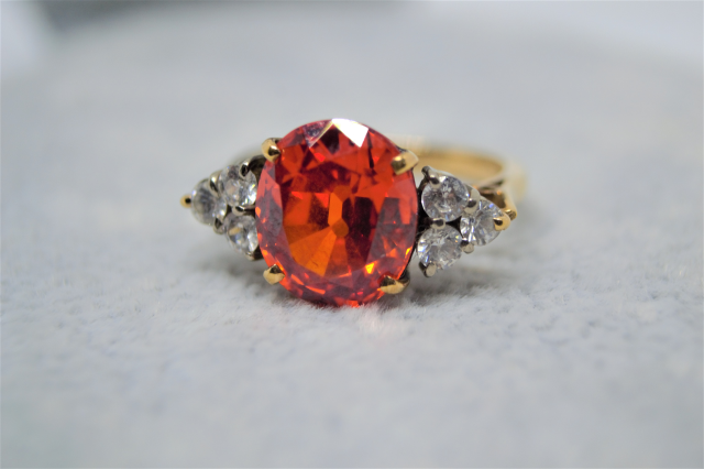 A 9ct Yellow  Gold And synthetic Orange spinel and White Sapphire Dress Ring. 