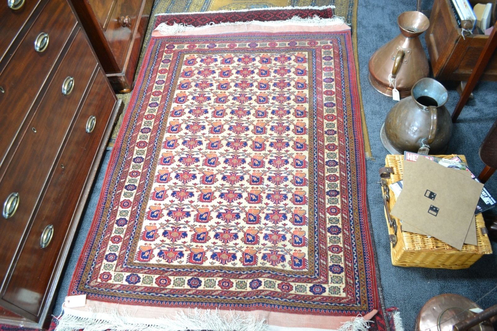 Turkish fringed carpet cream ground with designs in red and blue.