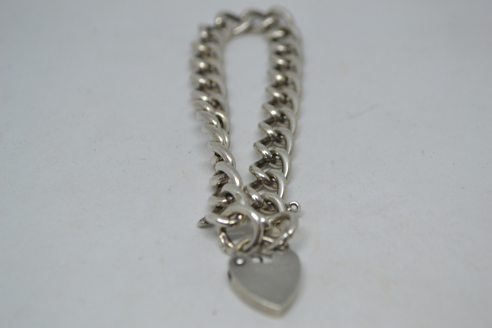 A Solid Sterling Silver Curb Link Bracelet  With Heart Padlock